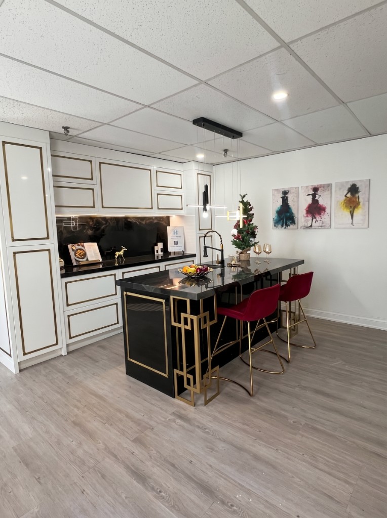 Kitchen vignette with black marble island and gold-trim cabinetry